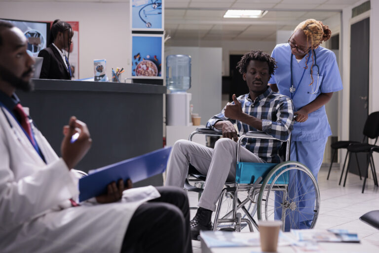 Person with chronic disability in waiting room at health center facility, wheelchair user waiting to attend checkup appointment. Man with physcal impairment doing consultation at medical clinic.